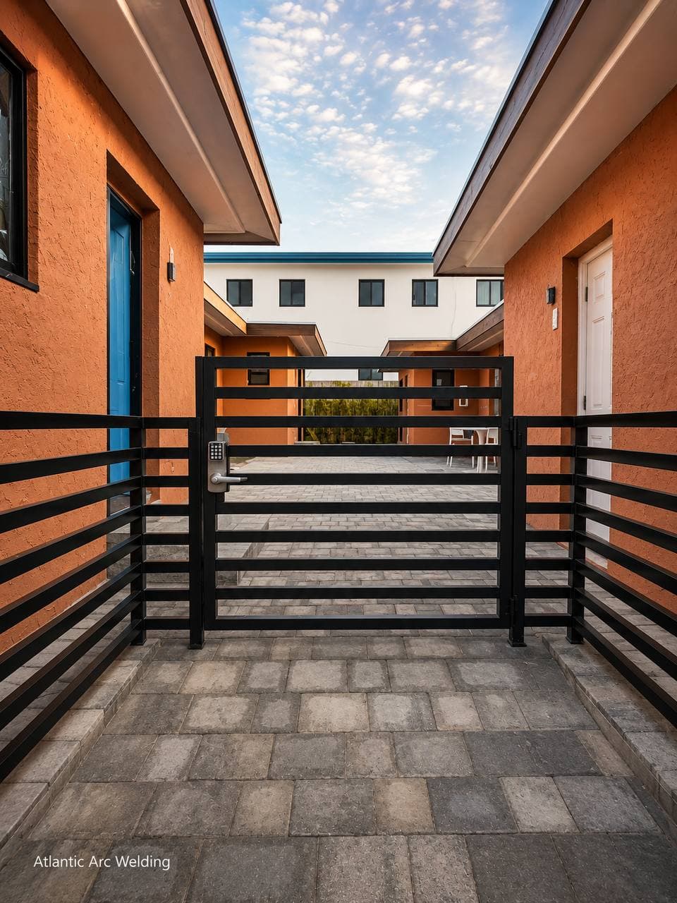 Horizontal-slat metal gate in a paved breezeway