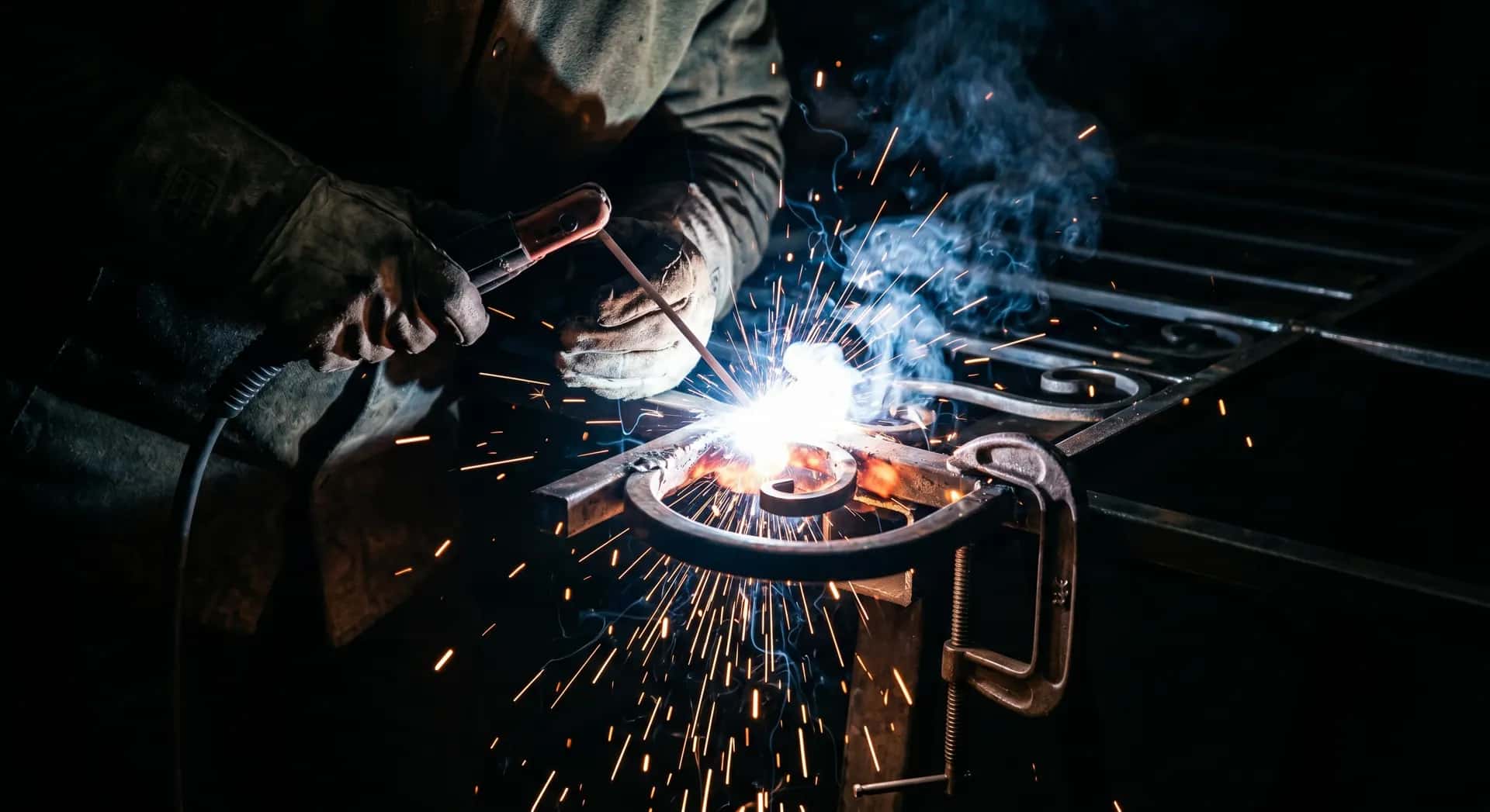 Welder working on a metal frame on-site with sparks flying