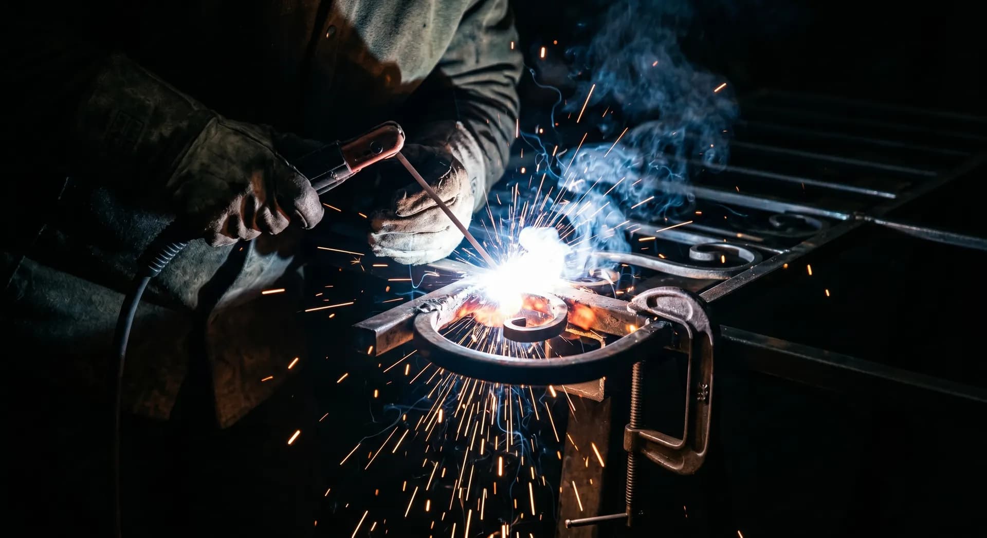 Welder working on a metal frame on-site with sparks flying